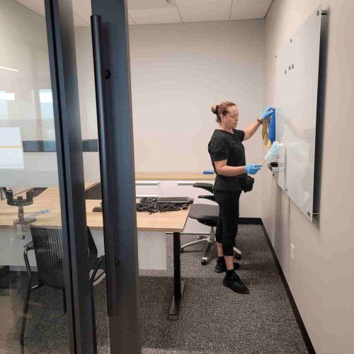 professional cleaner cleaning a office whiteboard during office cleaning services in Bartlett Il